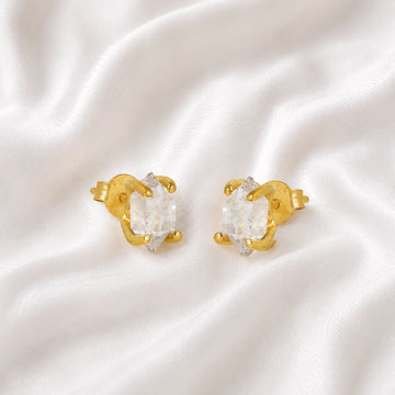 Crystal_earrings_in_gold_plated_silver_with_raw_herkimer_stone_at_slight_angle_view_on_soft_fabric_background