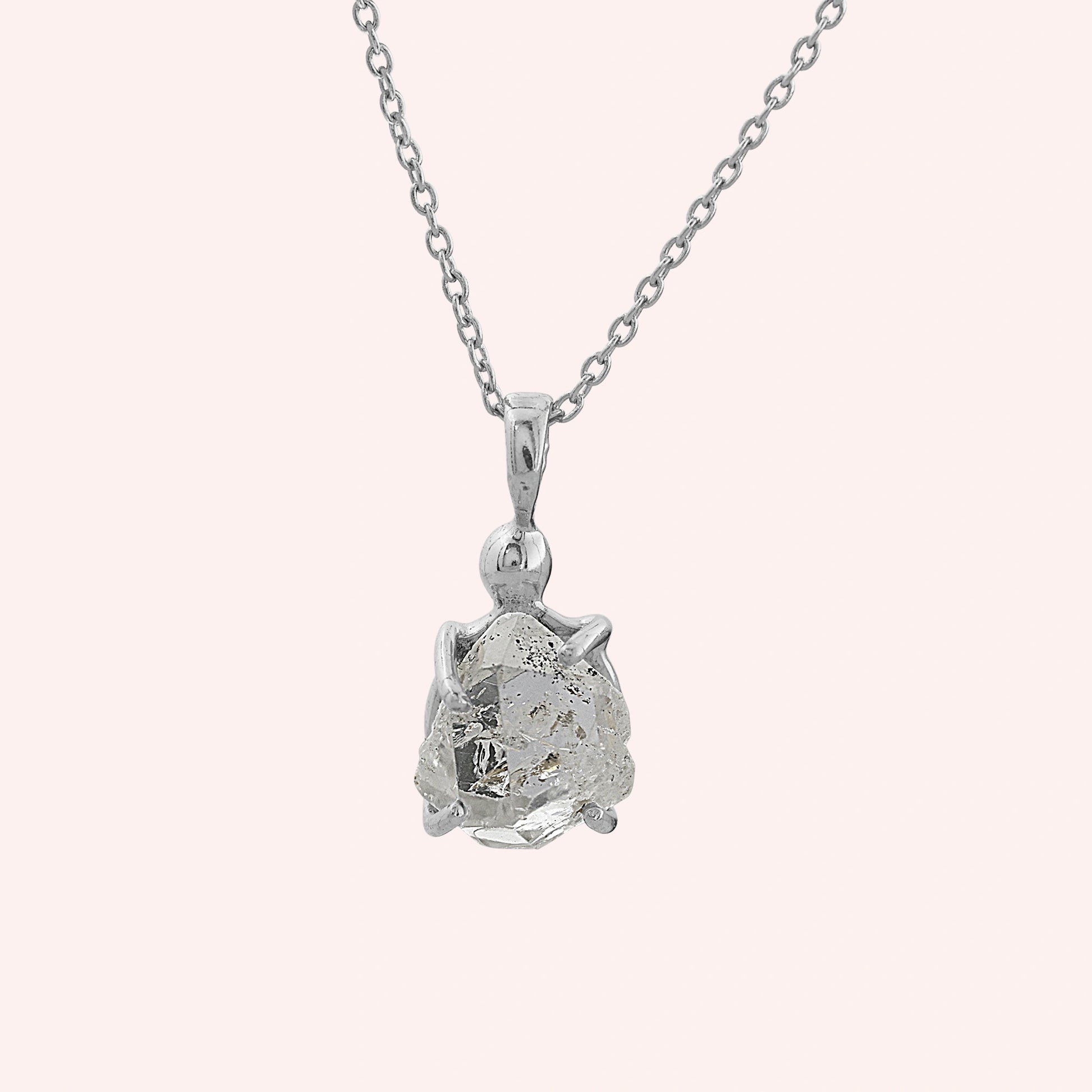 Crystal_necklace_in_sterling_silver_with_raw_stone_on_fine_chain_shown_in_front_angle_on_solid_pink_background