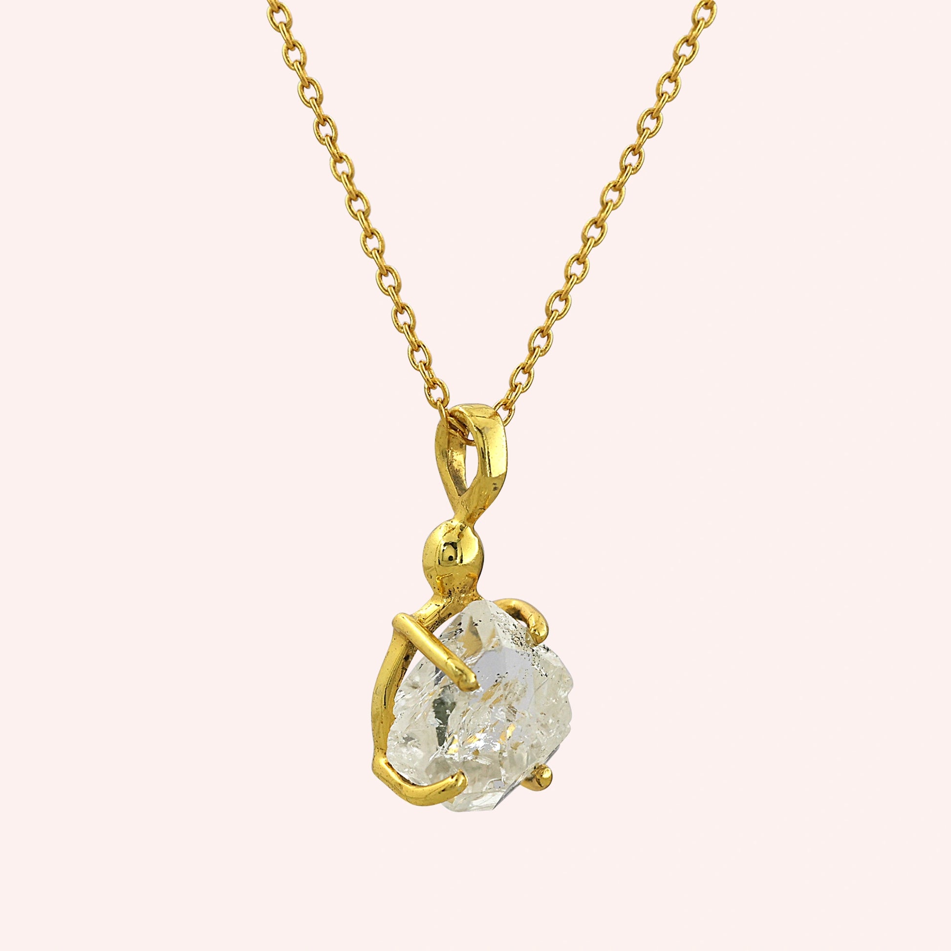 Crystal_necklace_in_gold_plated_silver_with_raw_stone_on_fine_chain_shown_in_slightly_angled_on_solid_pink_background