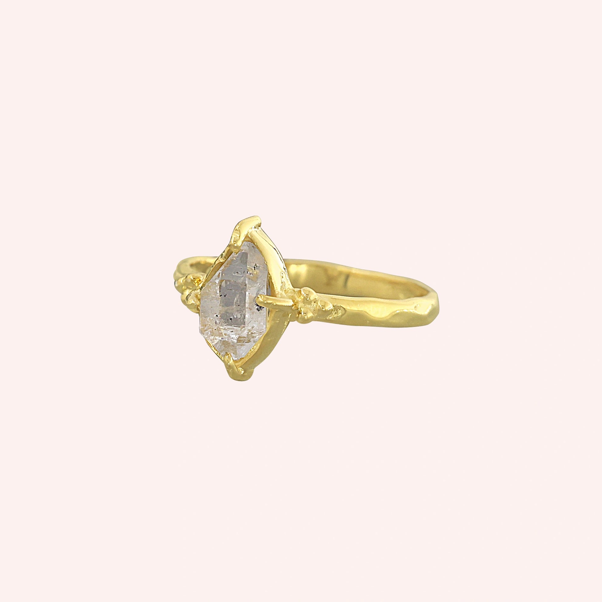 Crystal_ring_in_gold_plated_silver_with_raw_herkimer_stone_in_slight_tilted_view_on_soft_fabric_background