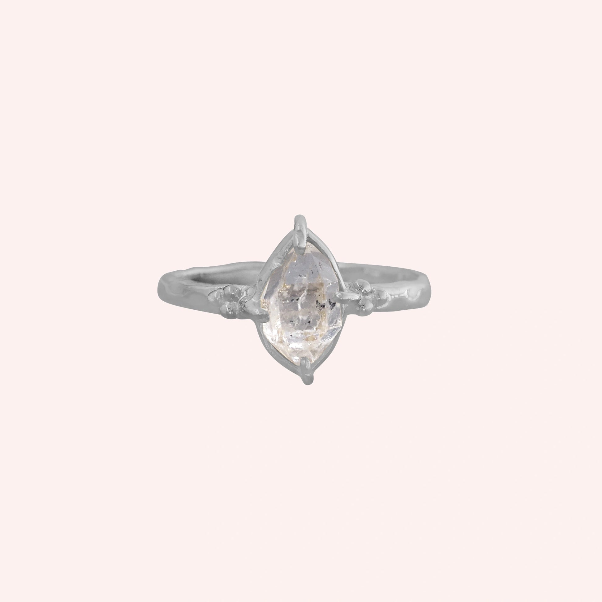 Crystal_ring_in_sterling_silver_with_raw_herkimer_stone_in_front_angle_view_on_solid_pink_background
