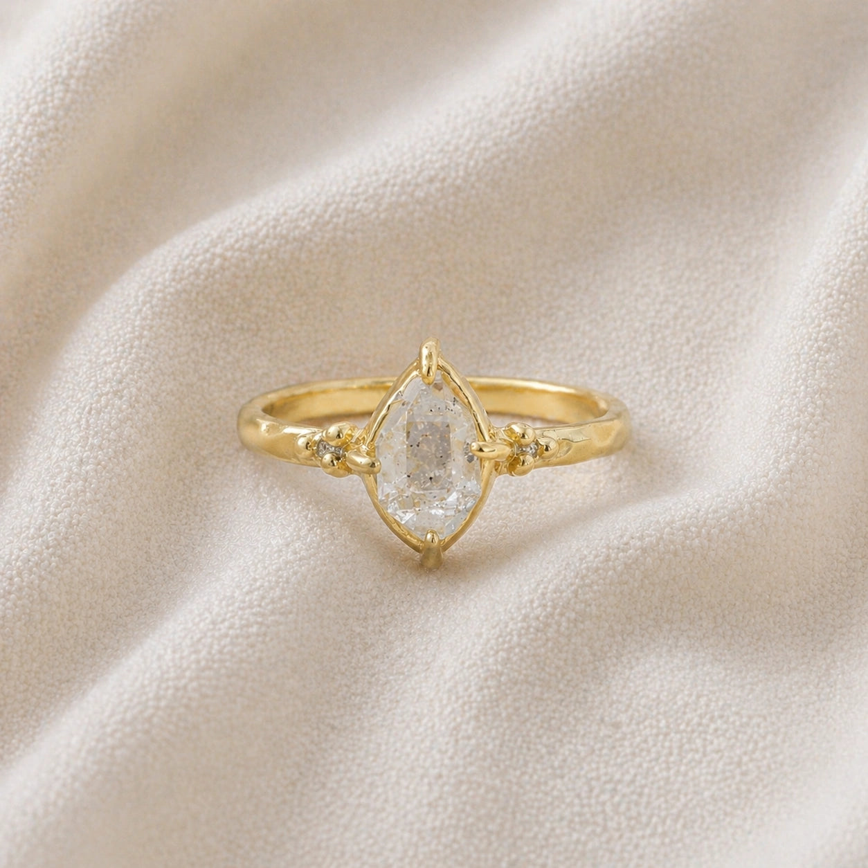 Crystal_ring_in_gold_plated_silver_with_raw_herkimer_stone_in_front_angle_view_on_soft_fabric_background