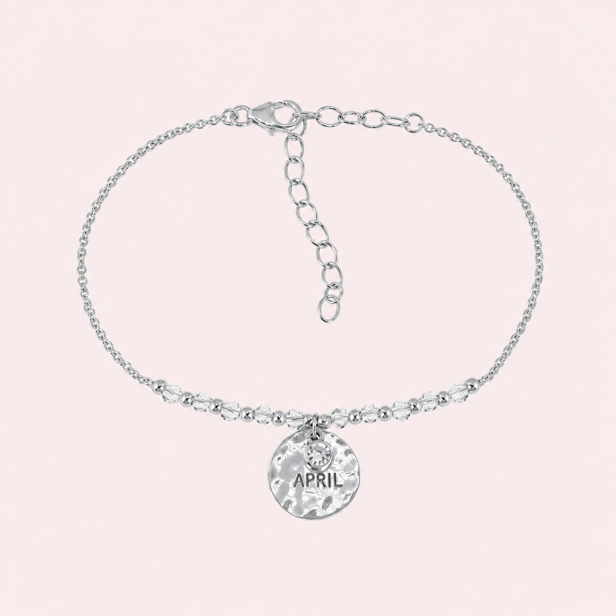 Birthstone_bracelet_in_sterling_silver_with_April_charm_and_crystal_beads_on_fine_chain_on_solid_pink_background