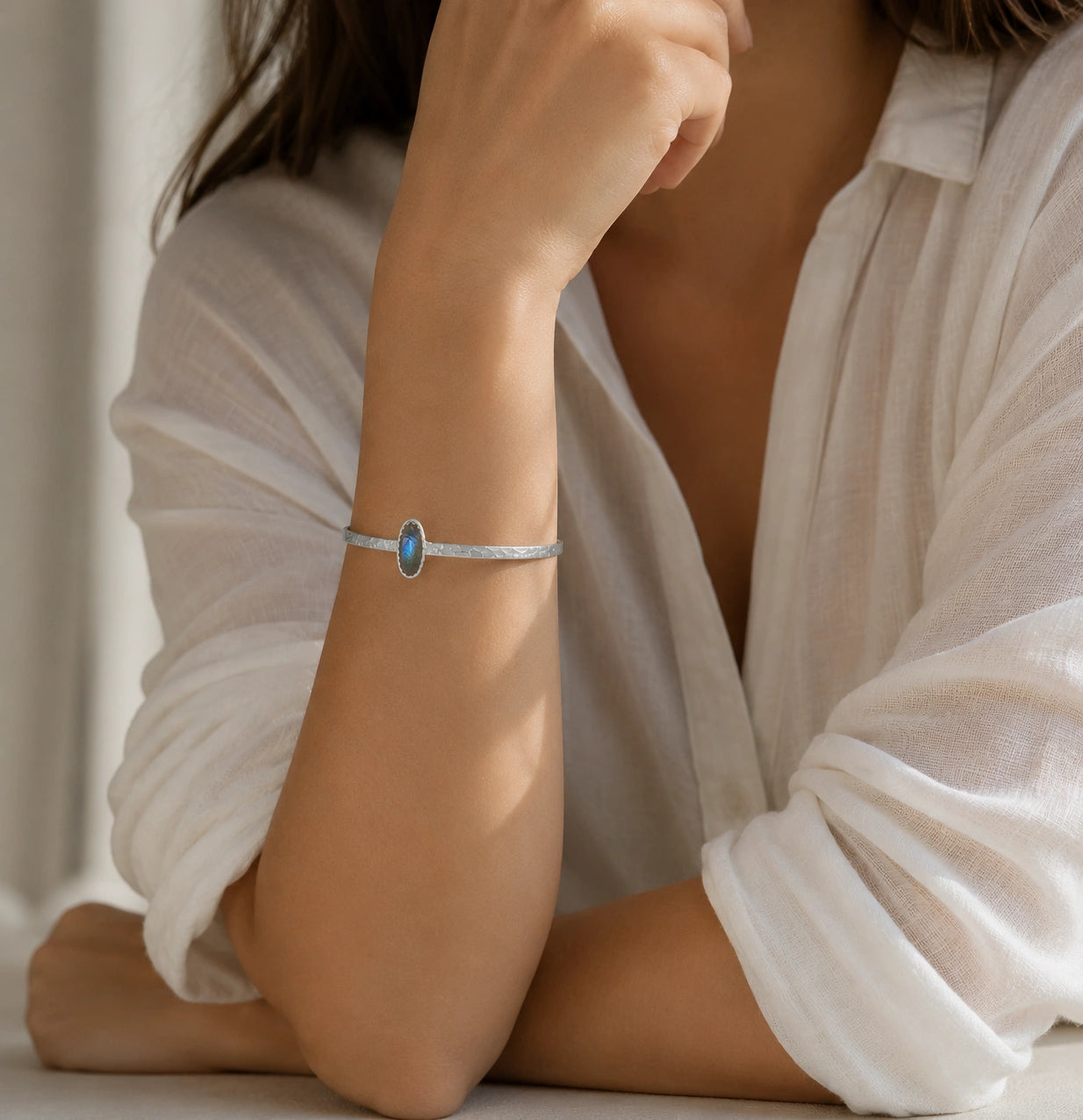 Cuff_bracelet_in_sterling_silver_with_an_oval_labradorite_stone_worn_by_a_model