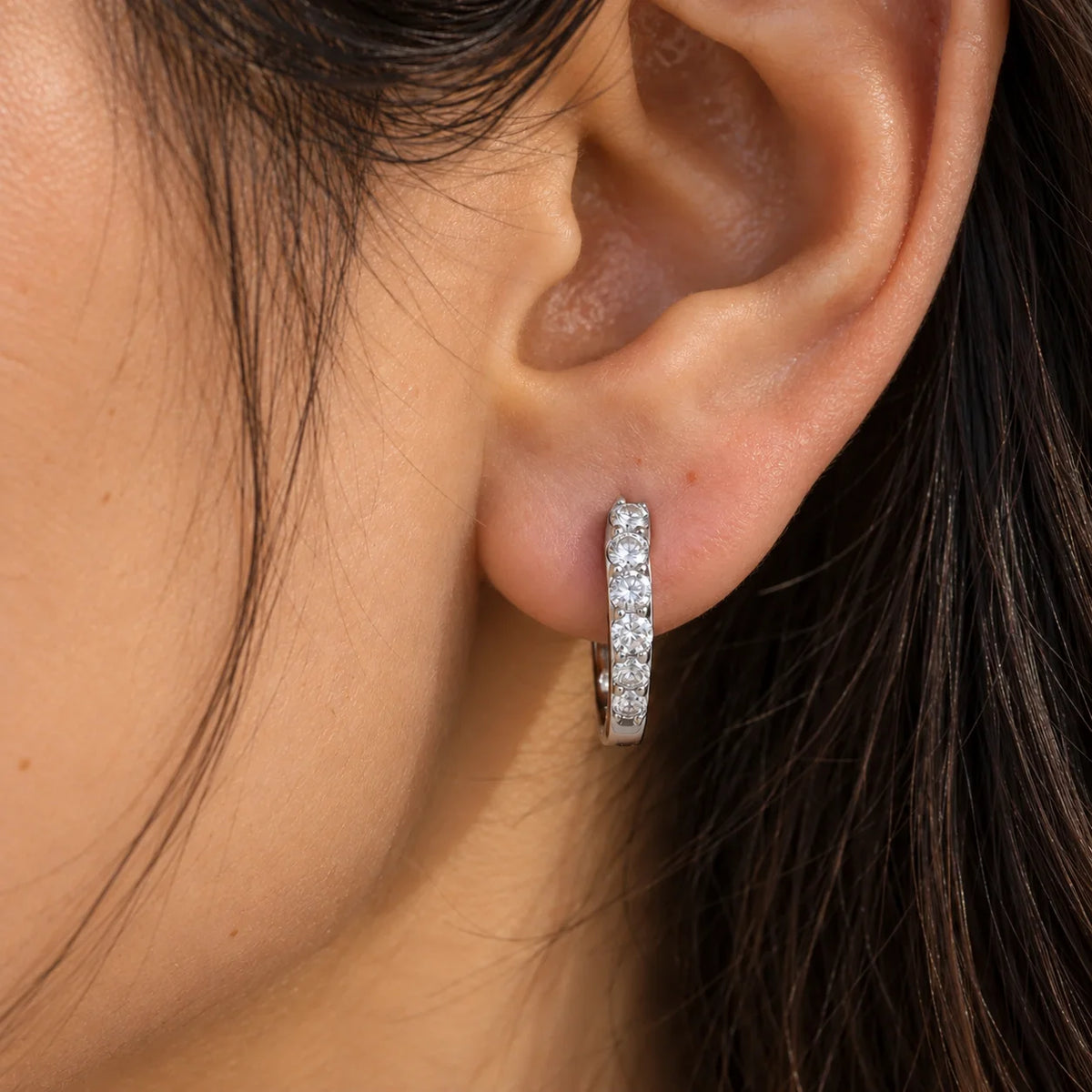 Cute_earrings_in_sterling_silver_with_CZ_stones_at_front_angle_view_worn_by_a_model