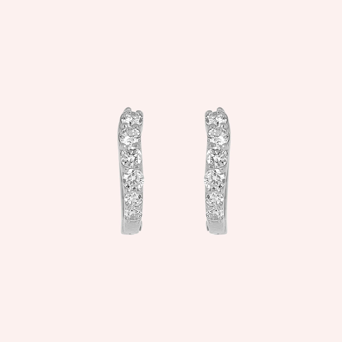 Cute_earrings_in_sterling_silver_with_CZ_stones_at_front_angle_view_on_solid_pink_background