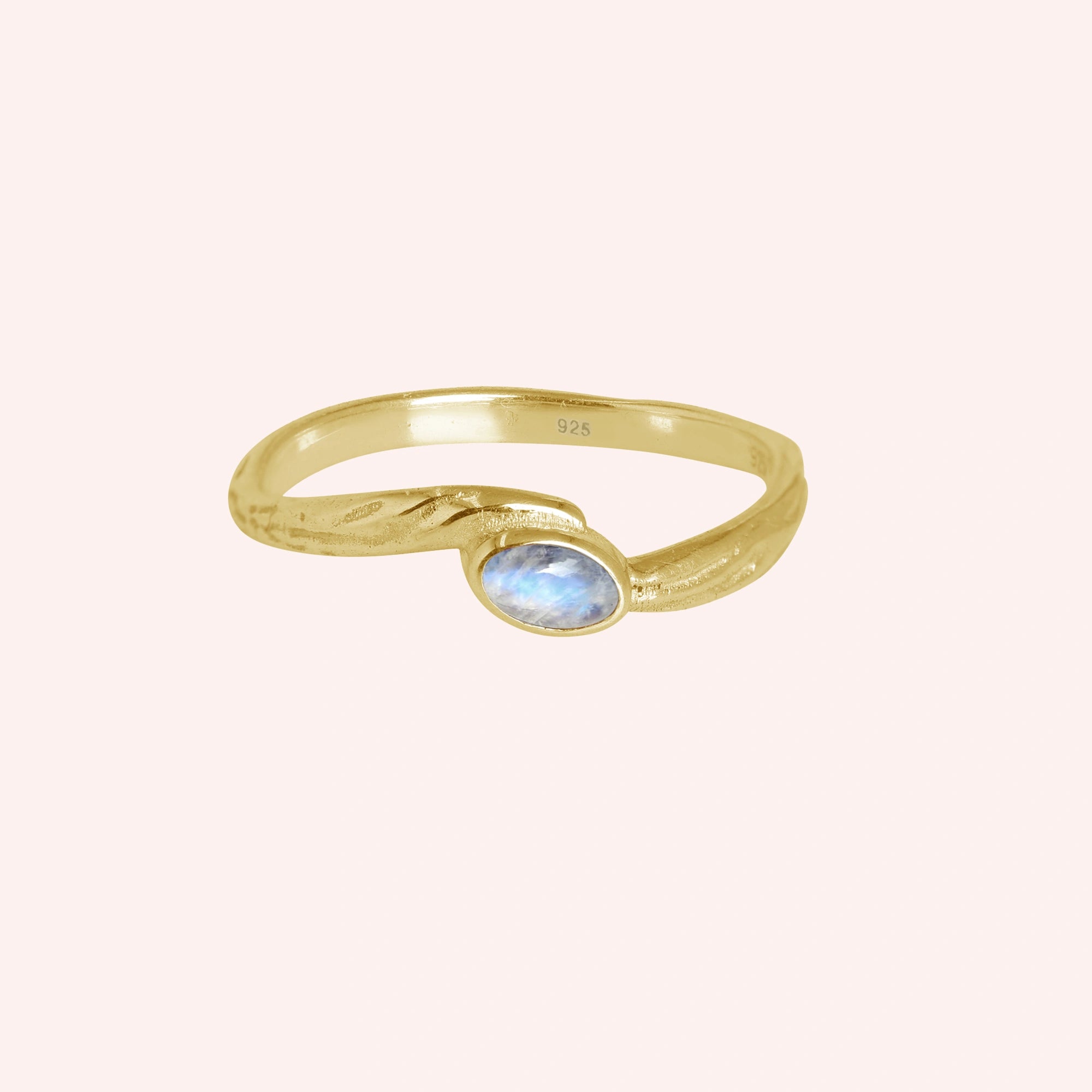 Cute_ring_gold_plated_silver_with_oval_moonstone_and_textured_wave_band_shown_at_front_angle_on_solid_pink_background