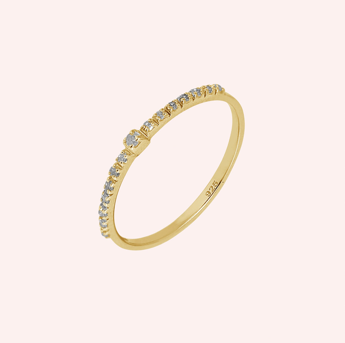 Dainty_ring_in_gold_plated_silver_at_front_angle_featuring_diamonds_on_solid_pink_background