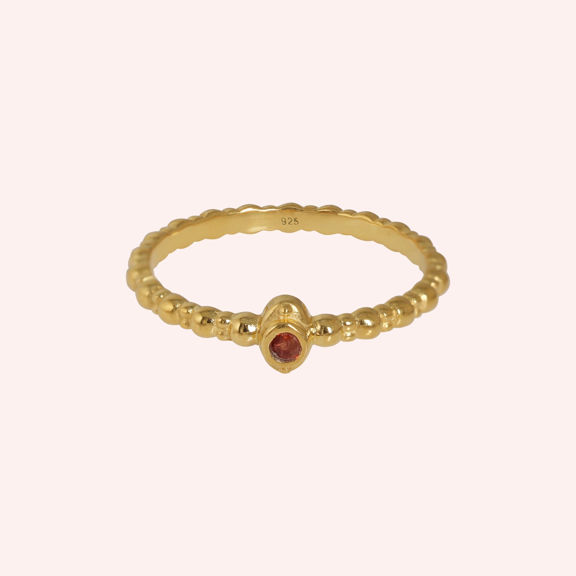 Dainty-ring-with-red-garnet-gemstone-gold-plated-silver-front-view-on-soft-pink-background