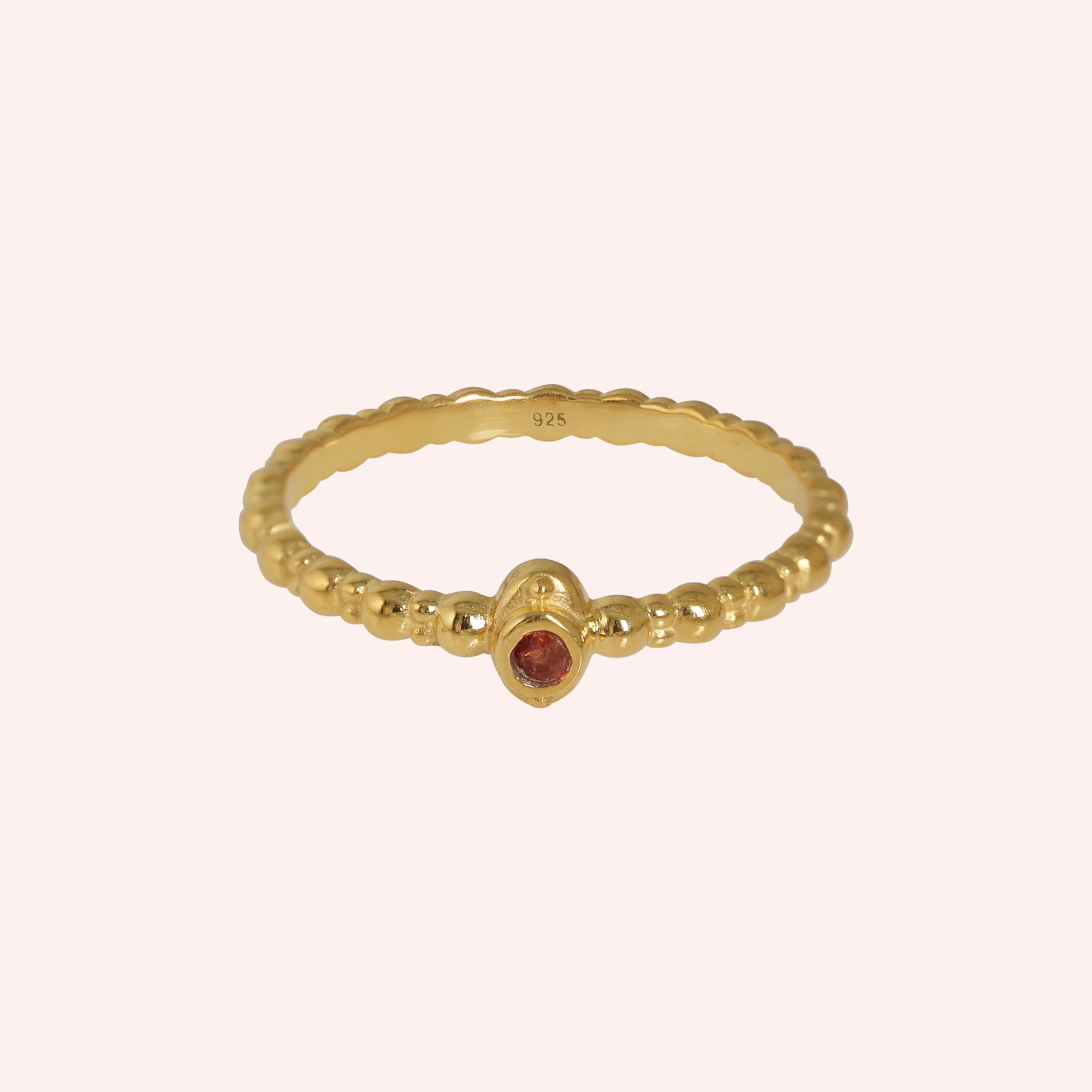 Dainty-ring-with-red-garnet-gemstone-gold-plated-silver-front-view-on-soft-pink-background