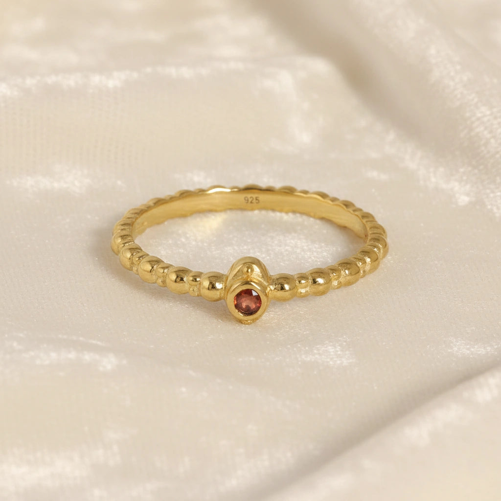 Dainty-ring-with-red-garnet-gemstone-gold-plated-silver-front-view-on-white-satin-background