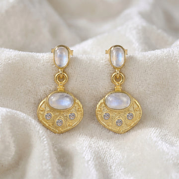 Dangle_earrings_in_gold_plated_silver_with_moonstone_and_labradorite_shown_at_front_angle_view_on_soft_velvet_fabric_background