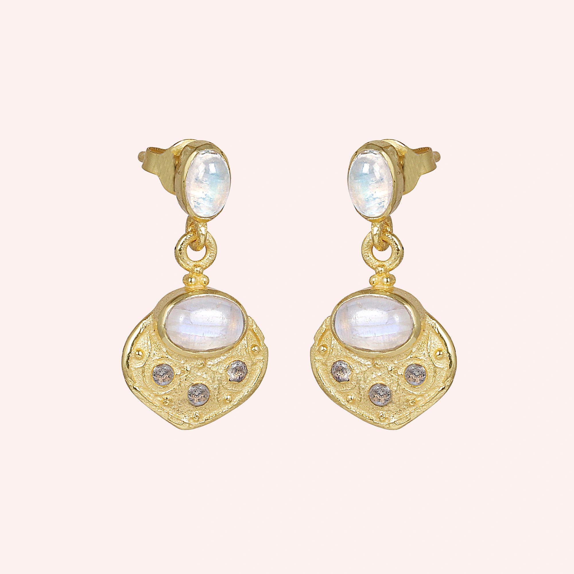Dangle_earrings_in_gold_plated_silver_with_moonstone_and_labradorite_shown_at_slightly_angled_on_solid_pink_background