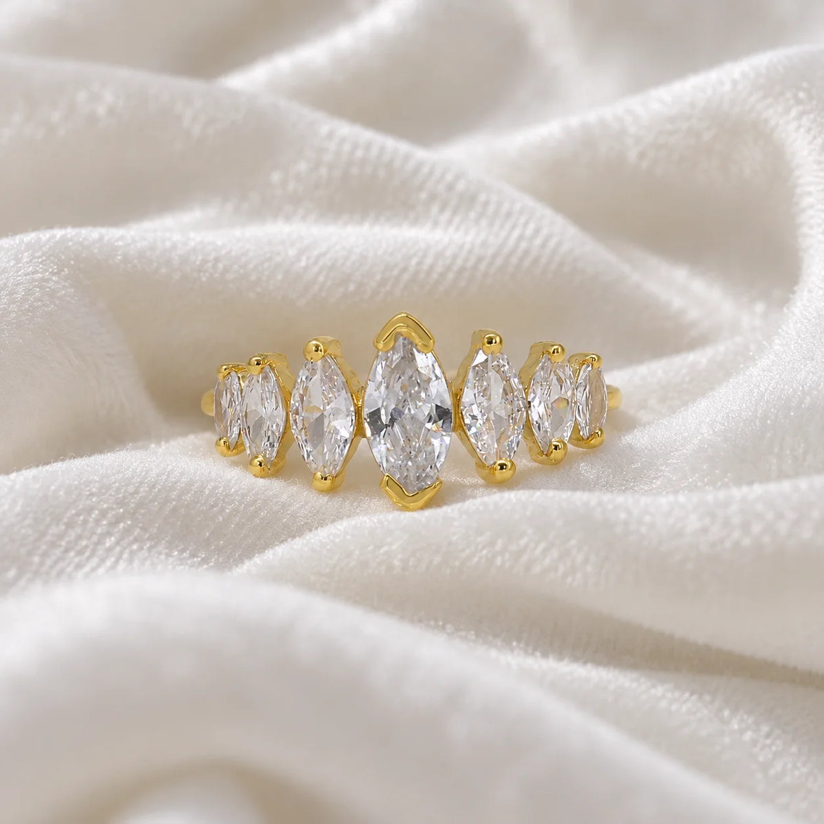 Designer_ring_in_gold_plated_silver_with_marquise_cut_CZ_stones_at_front_angle_view_on_soft_fabric_background