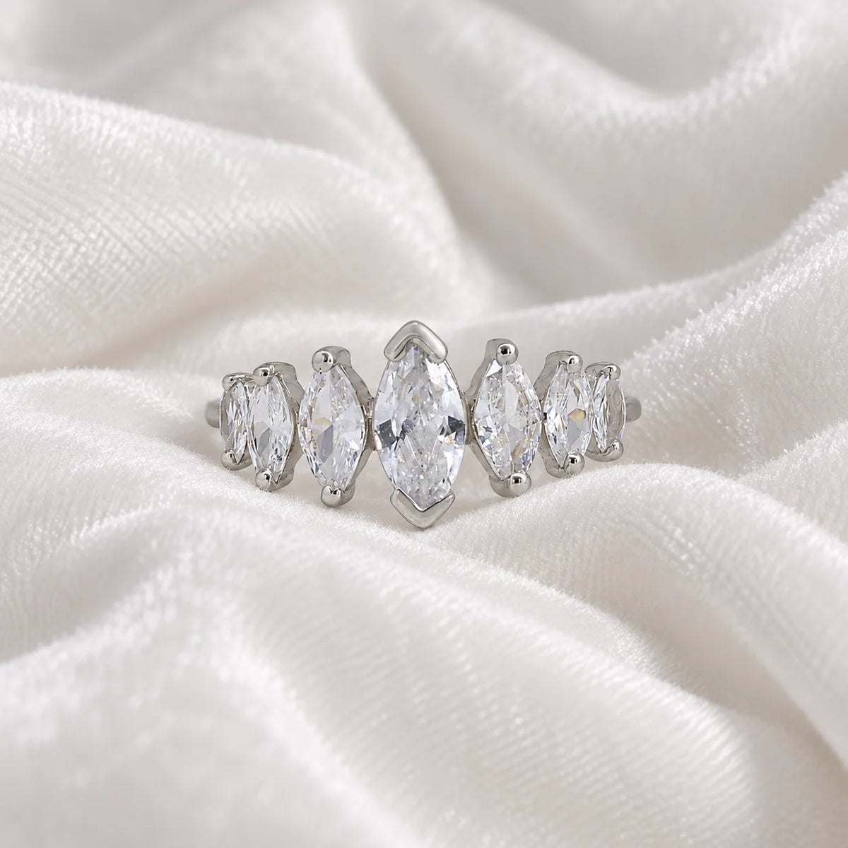 Designer_ring_in_sterling_silver_with_marquise_cut_CZ_stones_at_front_angle_view_on_soft_fabric_background