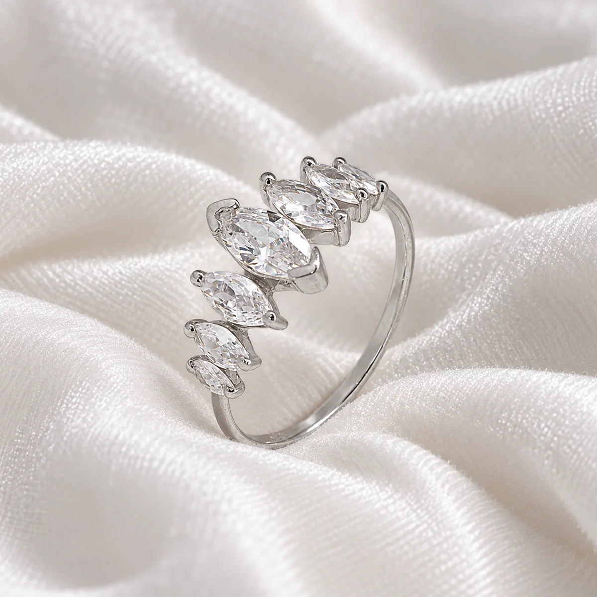 Designer_ring_in_sterling_silver_with_marquise_cut_CZ_stones_at_side_angle_view_on_soft_fabric_background