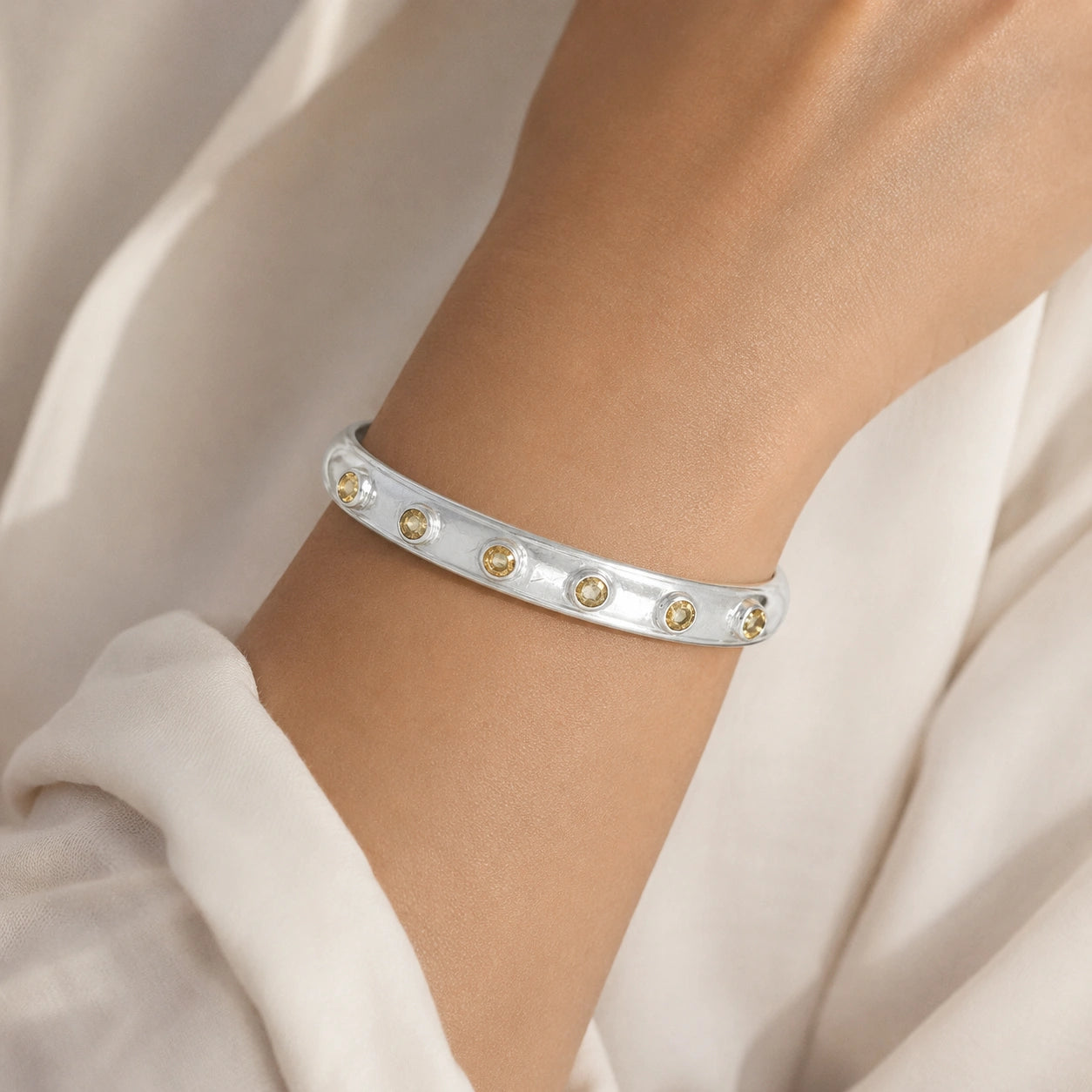 Designer_bangle_in_sterling_silver_with_bezel_set_citrine_stones_worn_by_a_model