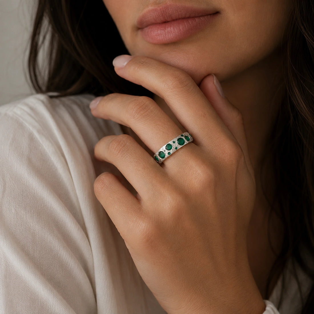 Designer_ring_in_gold_plated_silver_with_multiple_green_onyx_stones_at_slight_angle_on_soft_fabric_background