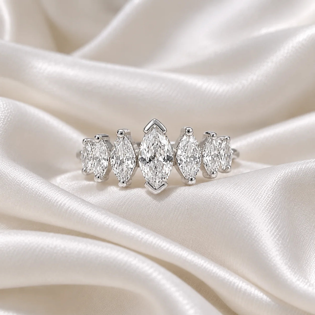 Designer_ring_in_sterling_silver_with_marquise_cut_lab_grown_diamonds_at_front_angle_view_on_soft_fabric_background