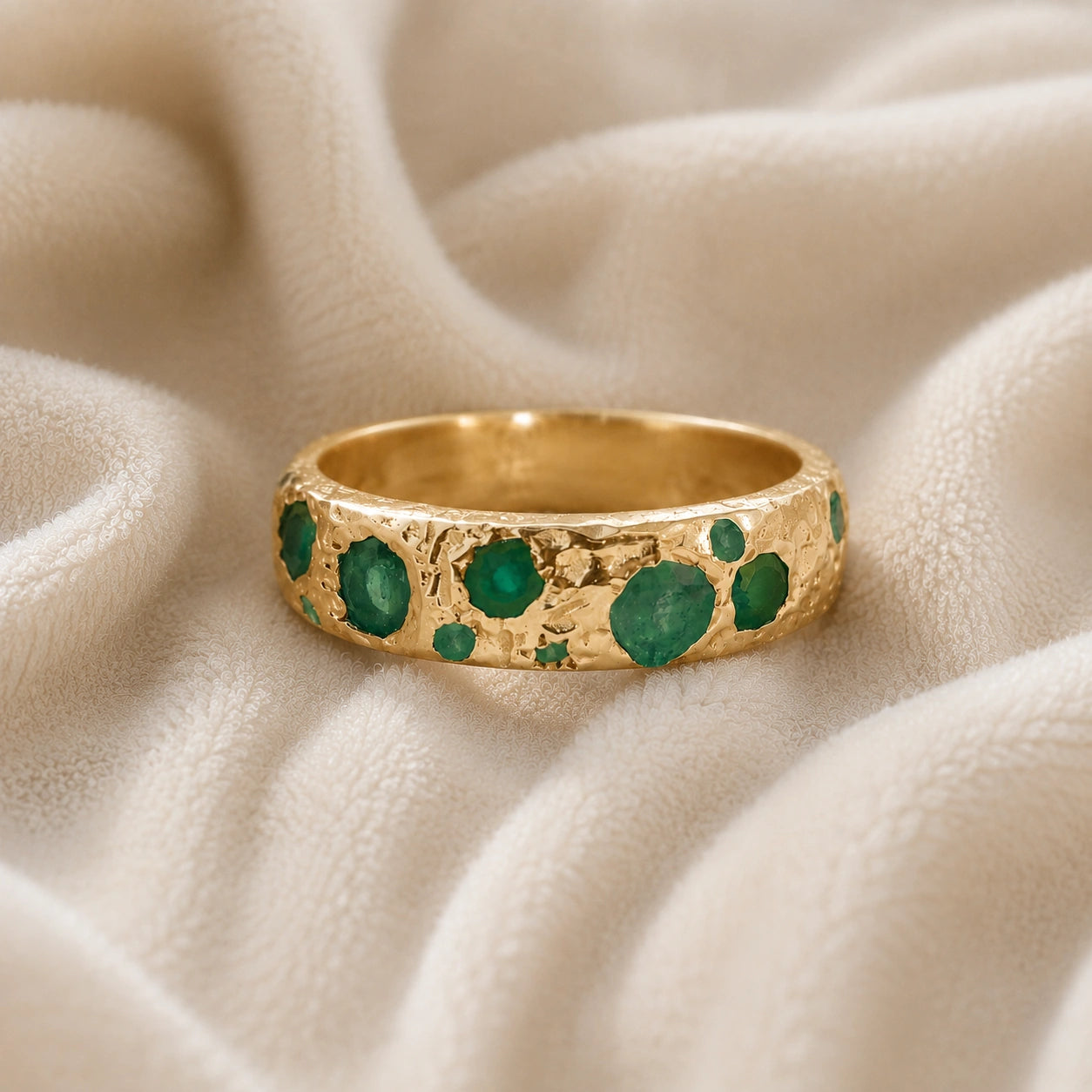 Designer_ring_in_gold_plated_silver_with_multiple_green_onyx_stones_at_front_angle_on_soft_fabric_background