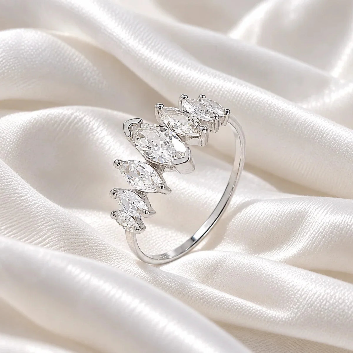 Designer_ring_in_sterling_silver_with_marquise_cut_lab_grown_diamonds_at_side_angle_view_on_soft_fabric_background
