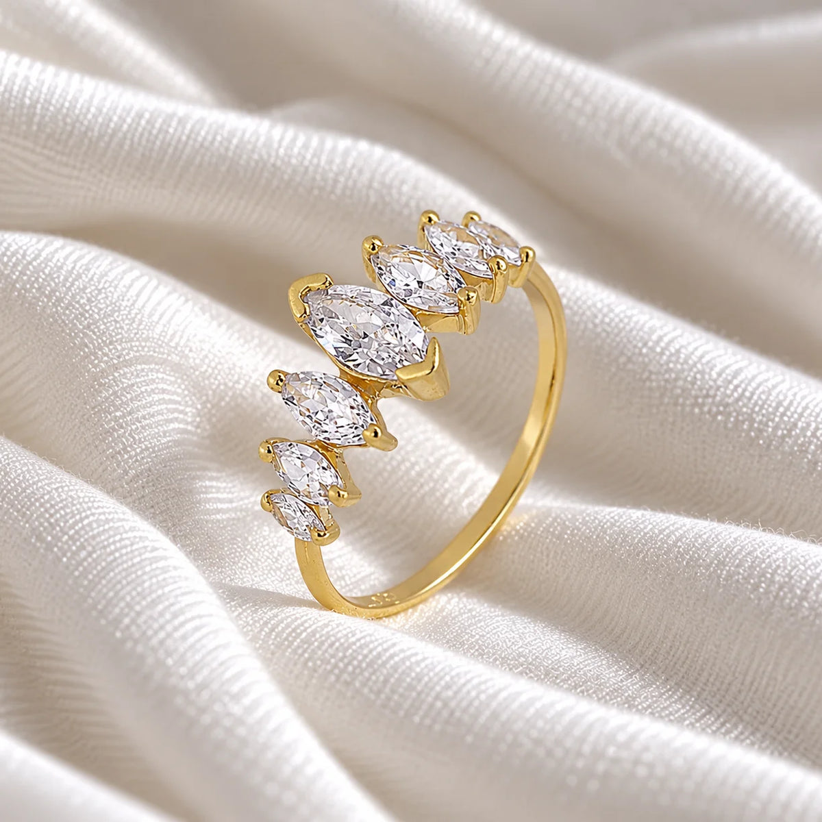 Designer_ring_in_gold_plated_silver_with_marquise_cut_lab_grown_diamonds_at_side_angle_view_on_soft_fabric_background