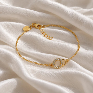 Diamond_bracelet_in_gold_plated_silver_in_an_interlocking_design_at_slight_angle_view_on_soft_fabric_background