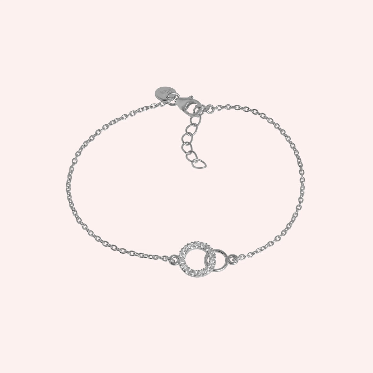 Diamond_bracelet_in_sterling_silver_in_an_interlocking_design_at_front_angle_view_on_solid_pink_background
