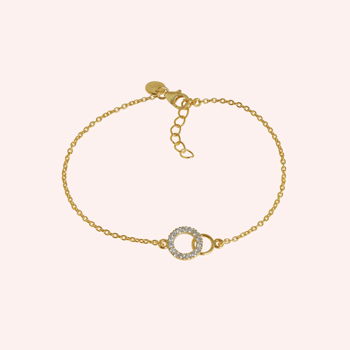 Diamond_bracelet_in_gold_plated_silver_in_an_interlocking_design_at_front_angle_view_on_solid_pink_background