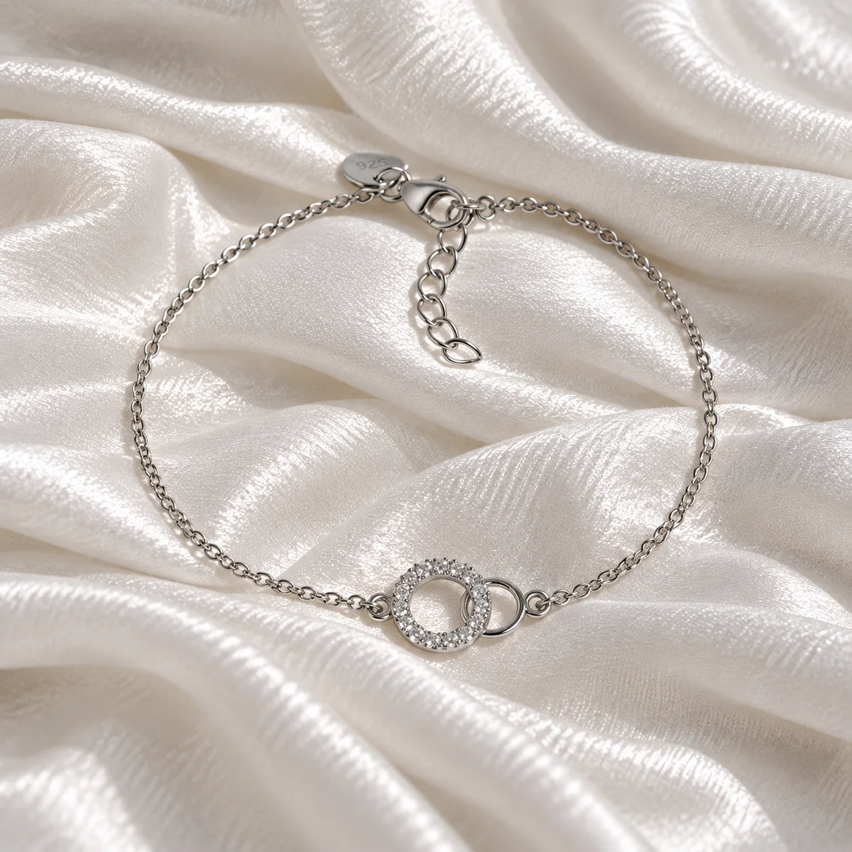 Diamond_bracelet_in_sterling_silver_in_an_interlocking_design_at_front_angle_view_on_soft_fabric_background