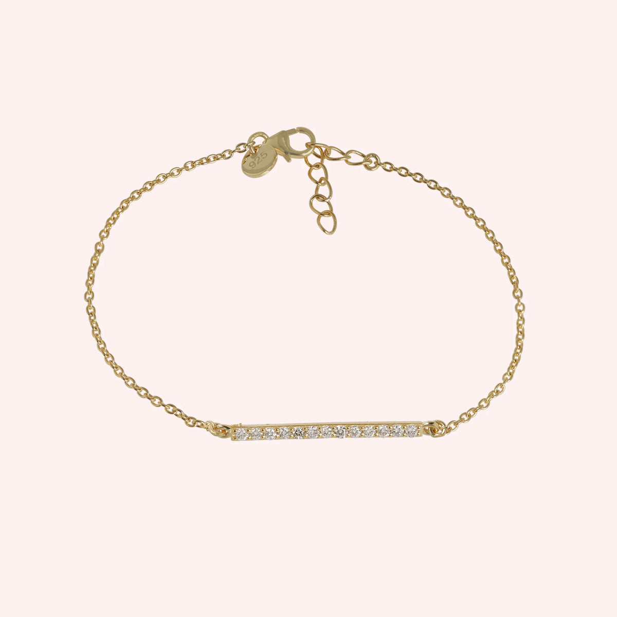 Diamond_bracelet_in_gold_plated_silver_with_a_bar_design_at_front_angle_view_on_solid_pink_background