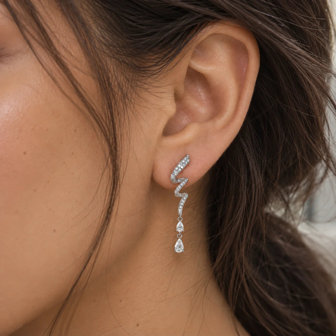 Diamond_drop_earrings_in_gold_plated_silver_with_twisted_design_lab_grown_diamonds_at_front_angle_view_on_soft_fabric_background