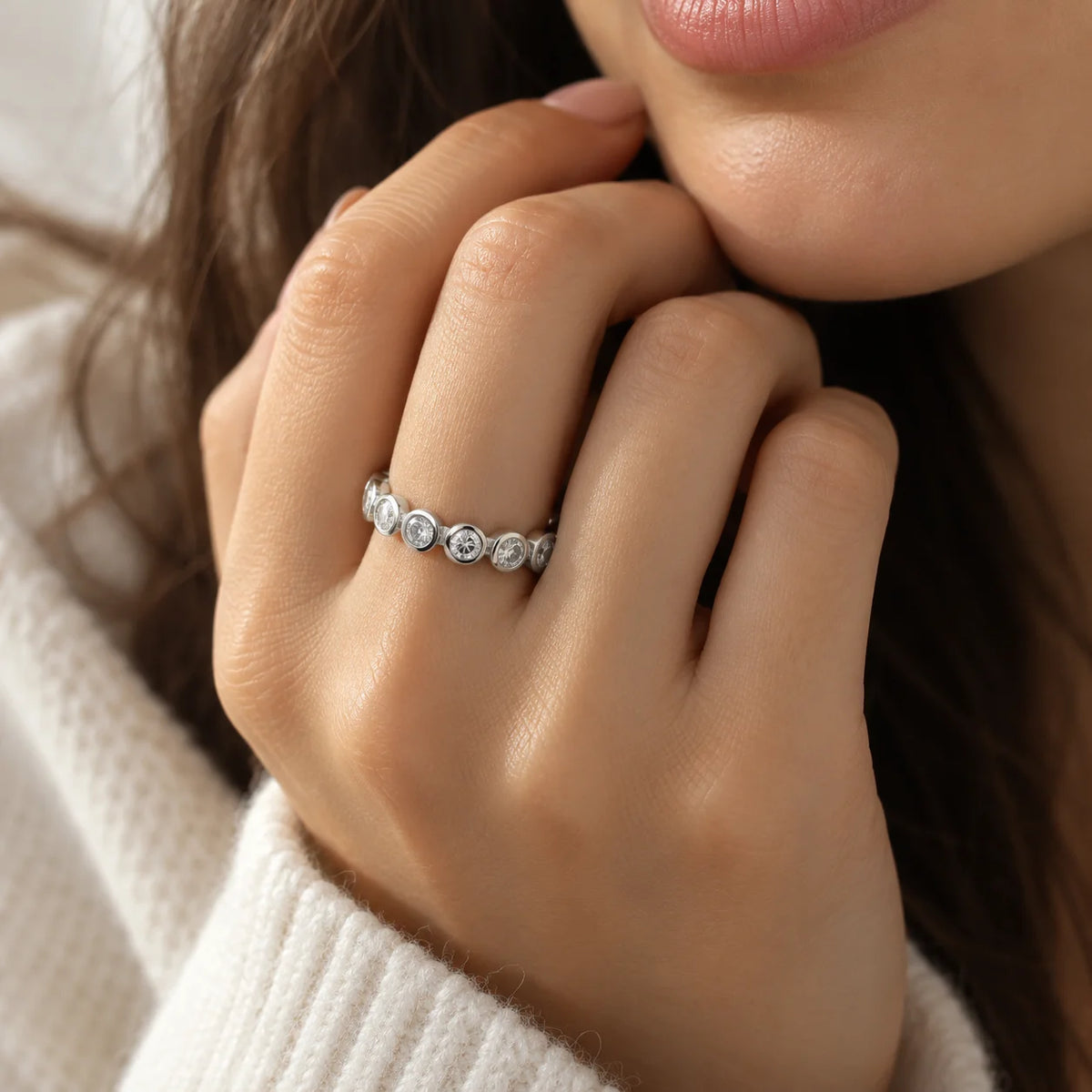 Diamond_eternity_ring_in_sterling_silver_with_lab_grown_diamonds_at_front_angle_worn_by_a_model