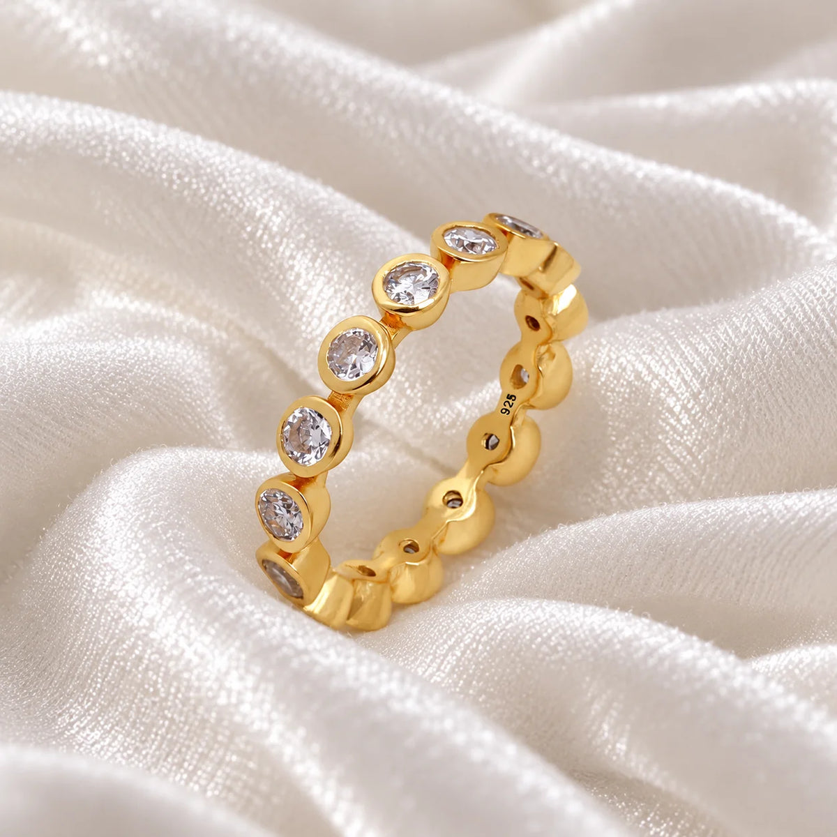 Diamond_eternity_ring_in_gold_plated_silver_with_lab_grown_diamonds_at_slight_angle_view_on_soft_fabric_background