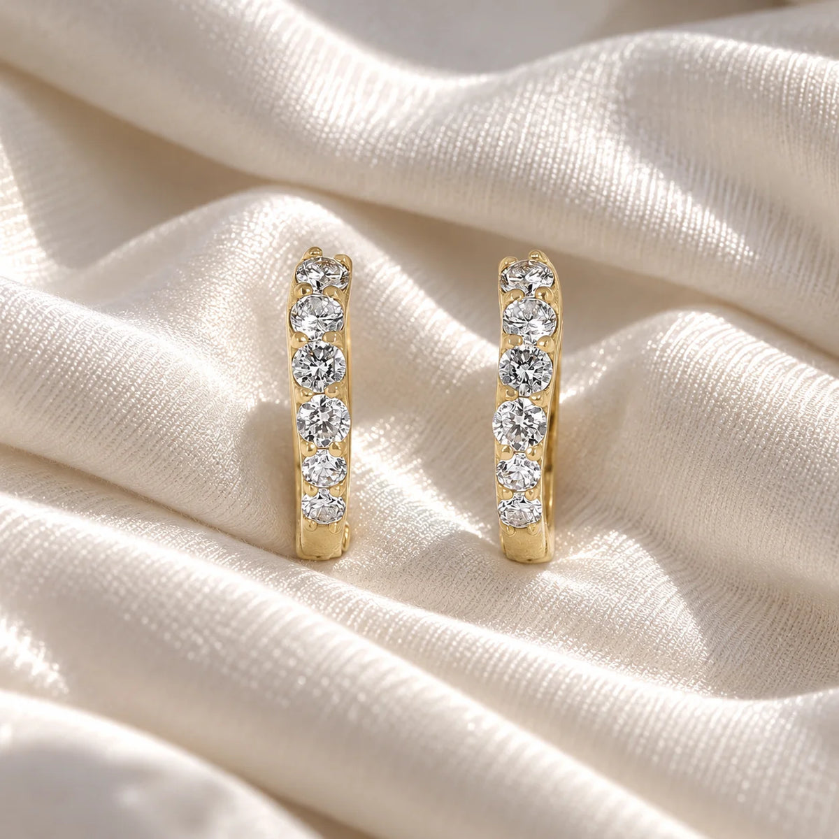 Diamond_hoop_earrings_in_gold_plated_silver_with_lab_grown_diamonds_at_front_angle_view_on_soft_fabric_background