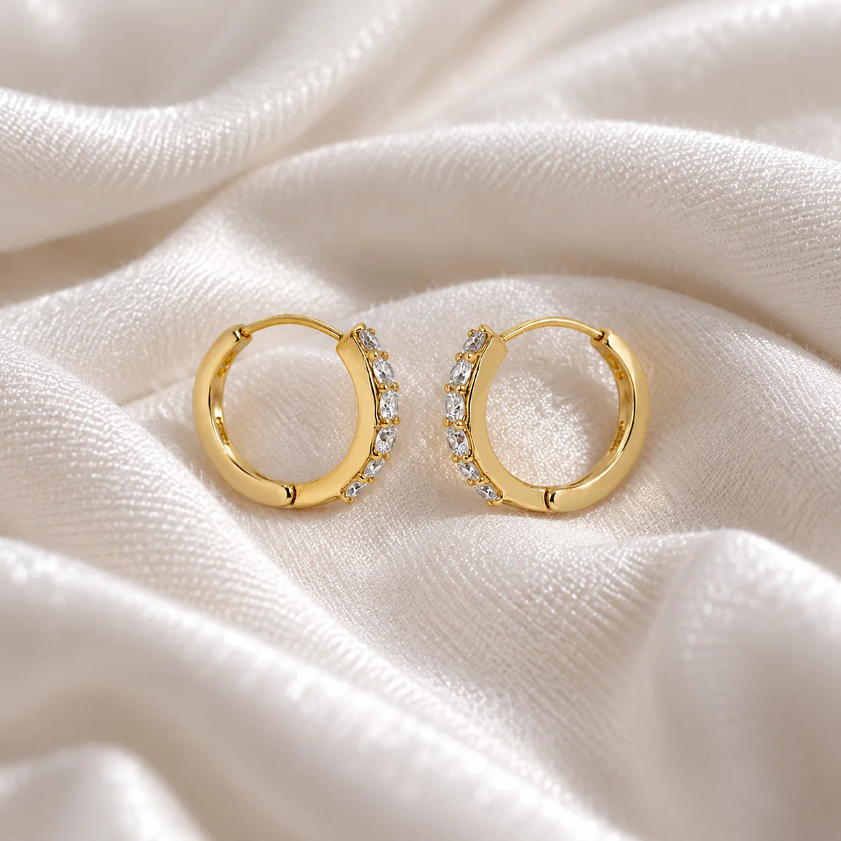Diamond_hoop_earrings_in_gold_plated_silver_with_lab_grown_diamonds_at_slight_angle_view_on_soft_fabric_background