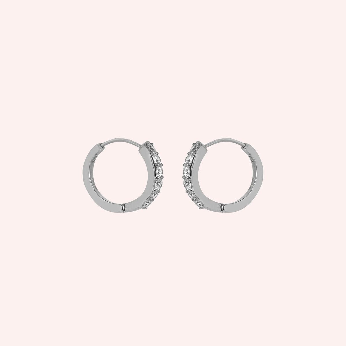 Diamond_hoop_earrings_in_sterling_silver_with_lab_grown_diamonds_at_slight_angle_view_on_solid_pink_background