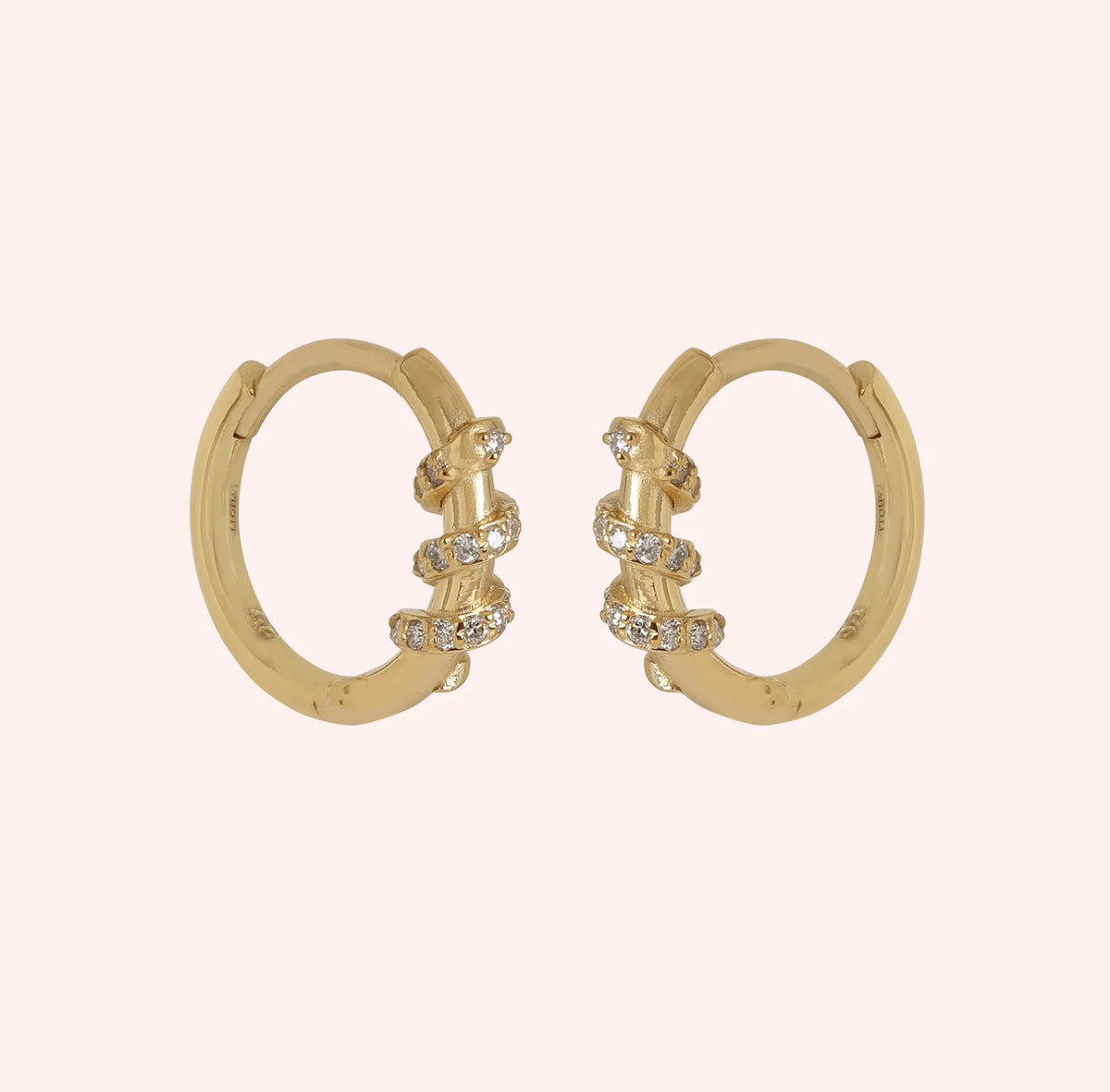 Diamond_hoop_earrings_in_gold_plated_silver_with_a_twisted_design_band_at_front_angle_view_on_solid_pink_background