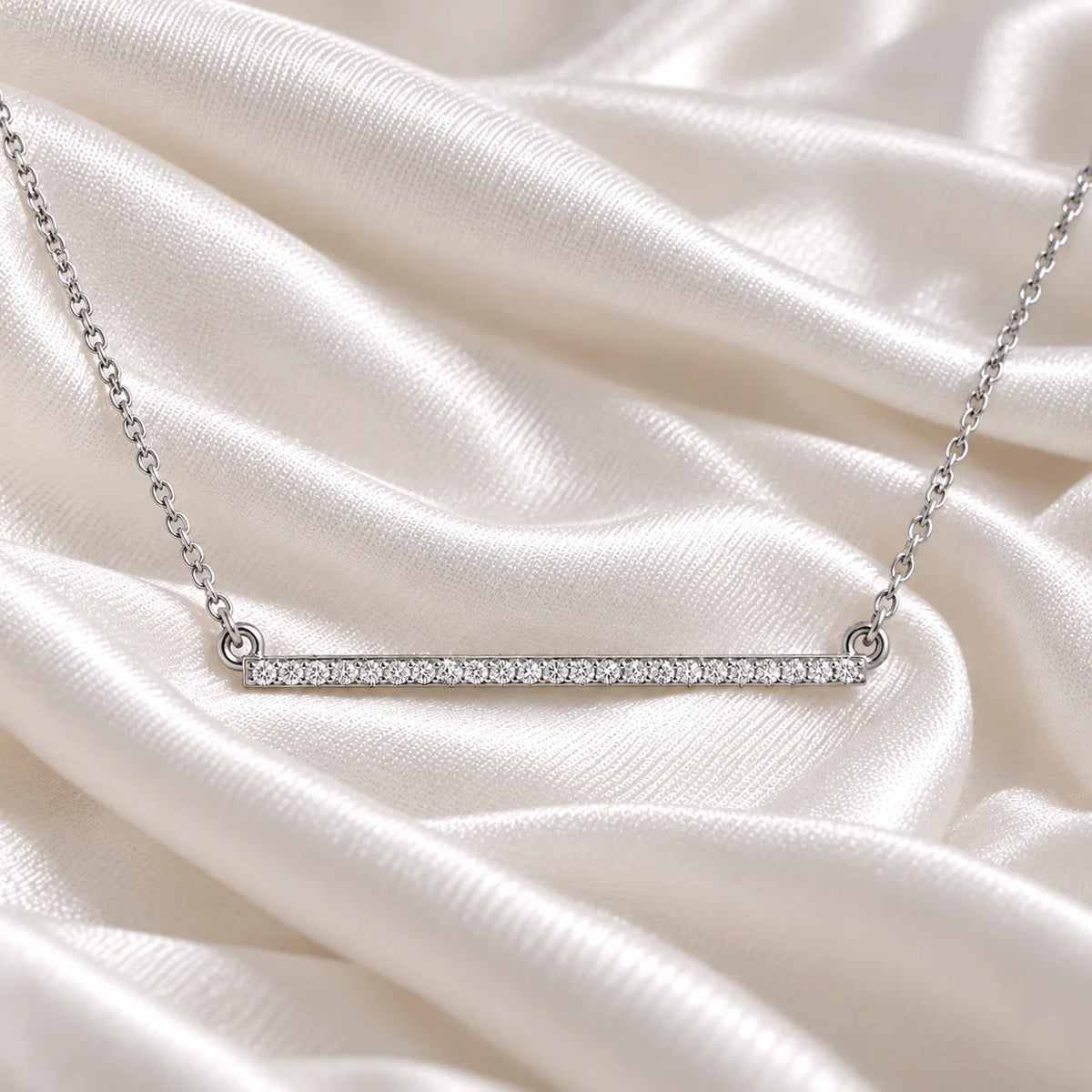 Diamond_necklace_in_sterling_silver_in_a_bar_design_at_front_angle_view_on_soft_fabric_background