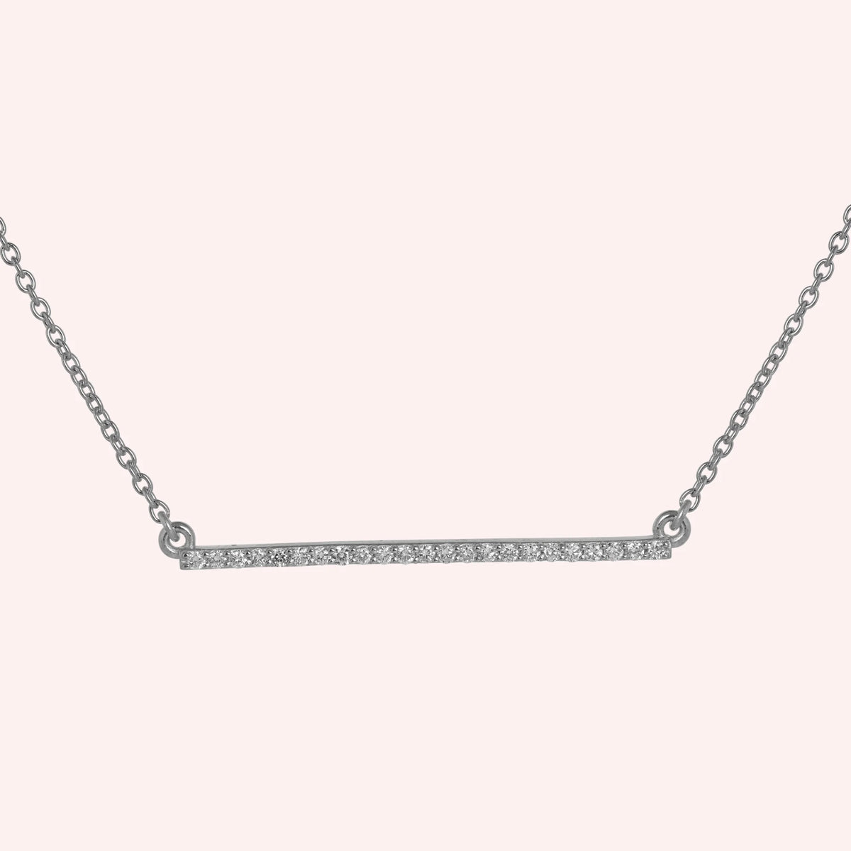 Diamond_necklace_in_sterling_silver_in_a_bar_design_at_front_angle_view_on_solid_pink_background
