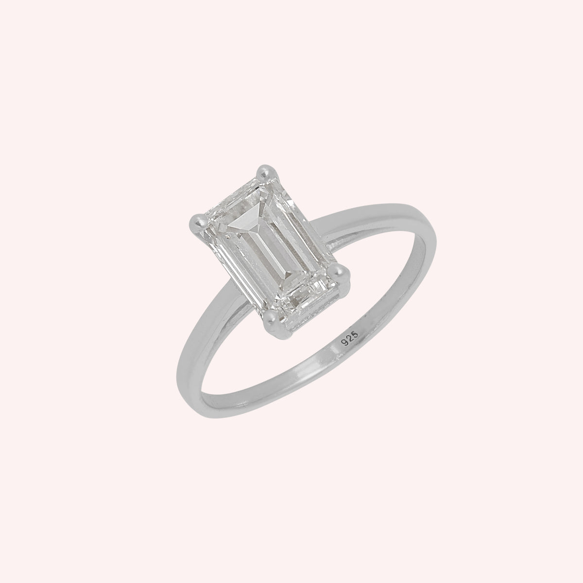 Diamond_ring_in_sterling_silver_with_a_lab_grown_baguette_shaped_diamond_at_slight_angle_view_on_solid_pink_background