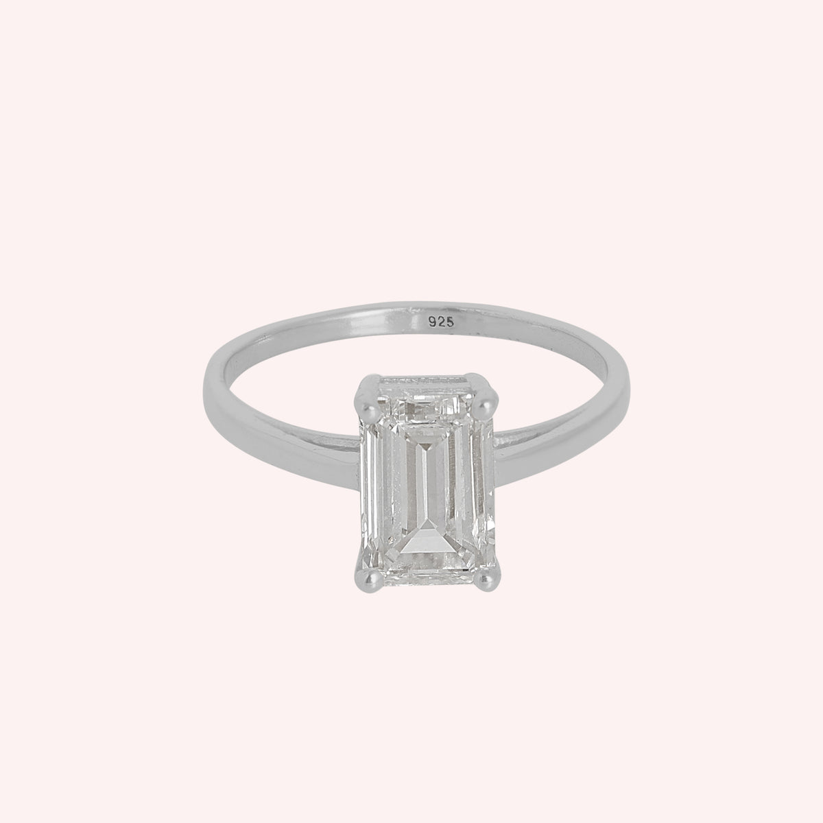 Diamond_ring_in_sterling_silver_with_a_lab_grown_baguette_shaped_diamond_at_front_angle_view_on_solid_pink_background