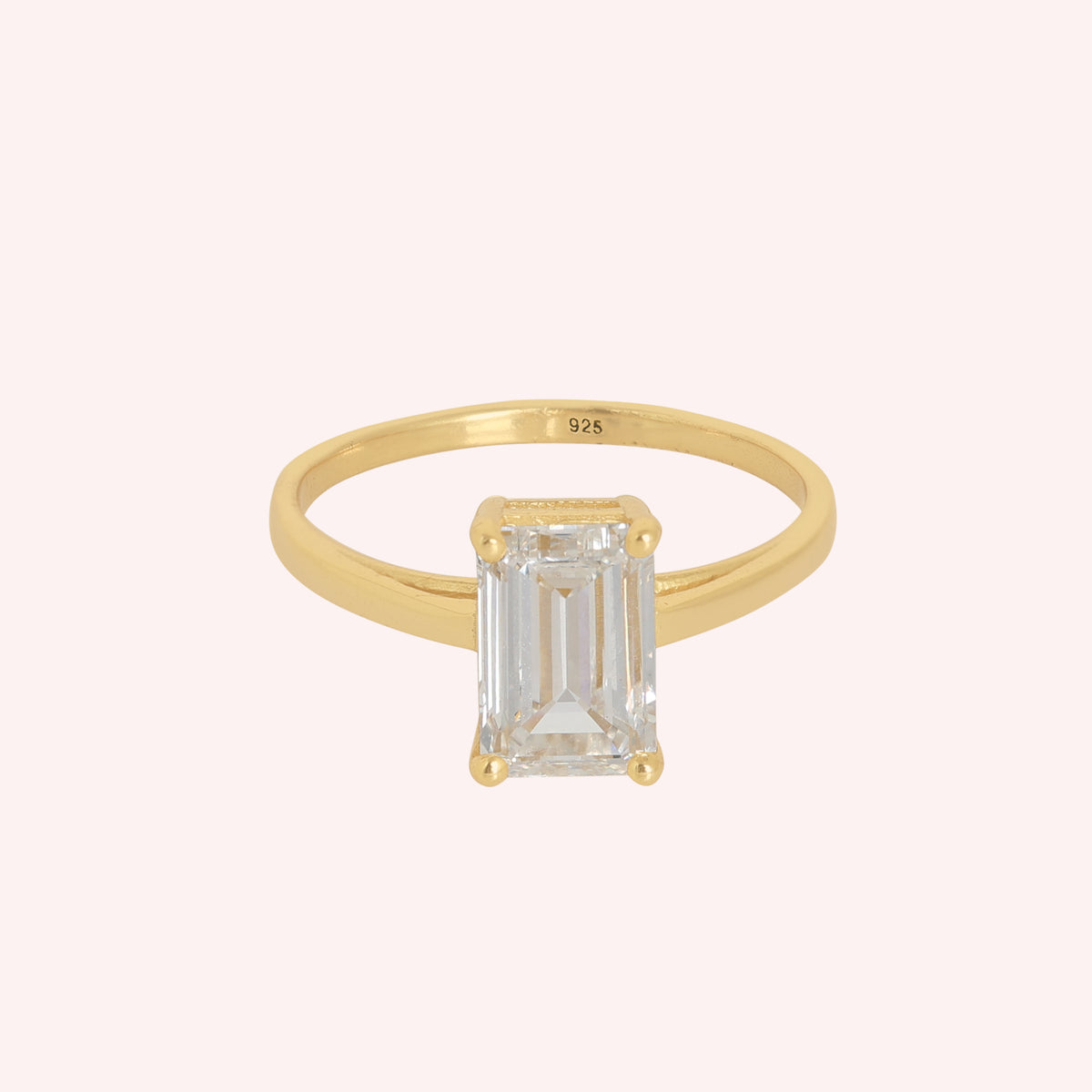 Diamond_ring_in_gold_plated_silver_with_a_lab_grown_baguette_shaped_diamond_at_front_angle_view_on_solid_pink_background