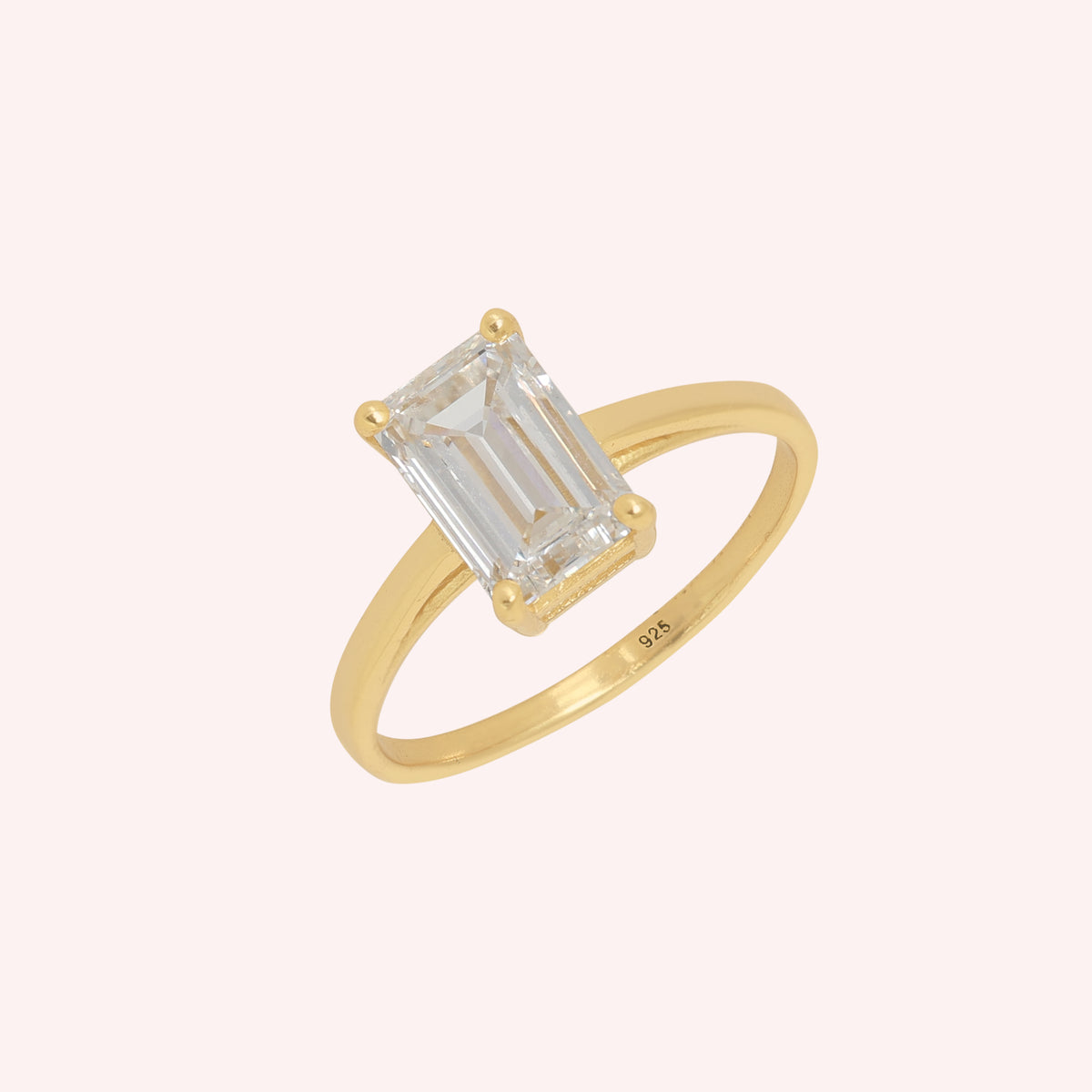Diamond_ring_in_gold_plated_silver_with_a_lab_grown_baguette_shaped_diamond_at_slight_angle_view_on_solid_pink_background