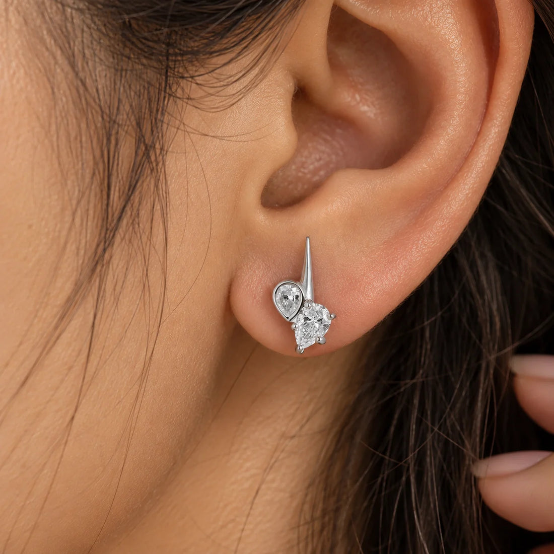 Diamond_stud_earrings_in_gold_plated_silver_with_teardrop_shaped_diamonds_at_front_angle_view_on_soft_fabric_background