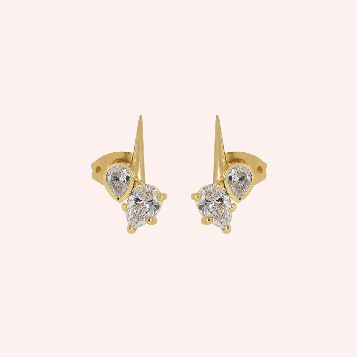 Diamond_stud_earrings_in_gold_plated_silver_with_teardrop_shaped_diamonds_at_front_angle_view_on_solid_pink_background