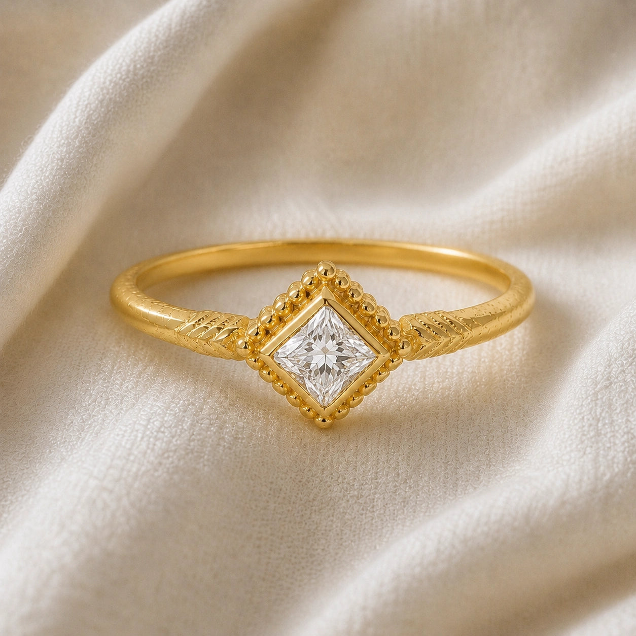 Princess_cut_ring_gold_plated_silver_with_square_diamond_and_detailed_band_front_angle_view_on_soft_fabric_background