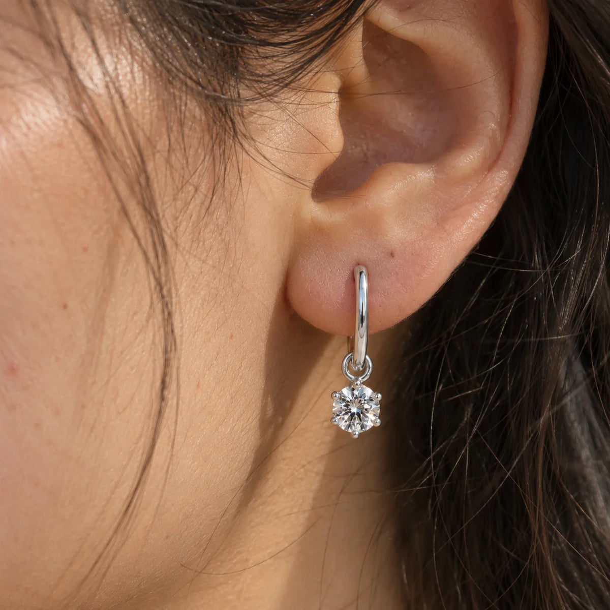 Diamond_earrings_in_sterling_silver_with_a_hoop_drop_design_worn_by_a_model