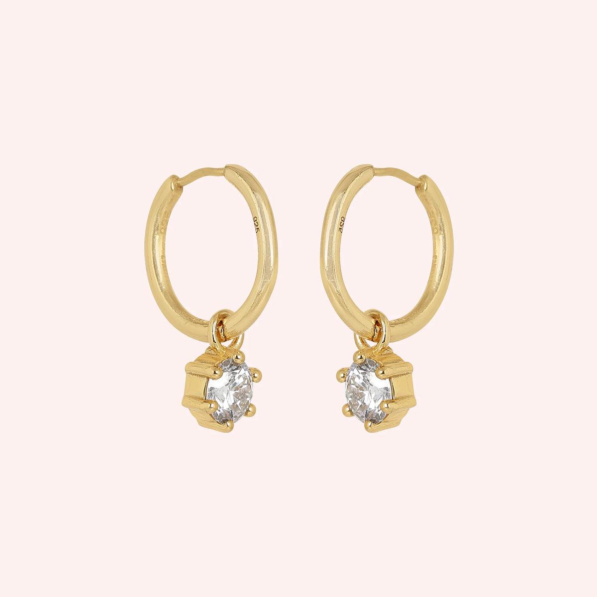 Diamond_earrings_in_gold_plated_silver_with_a_hoop_drop_design_at_slight_angled_view_on_solid_pink_background