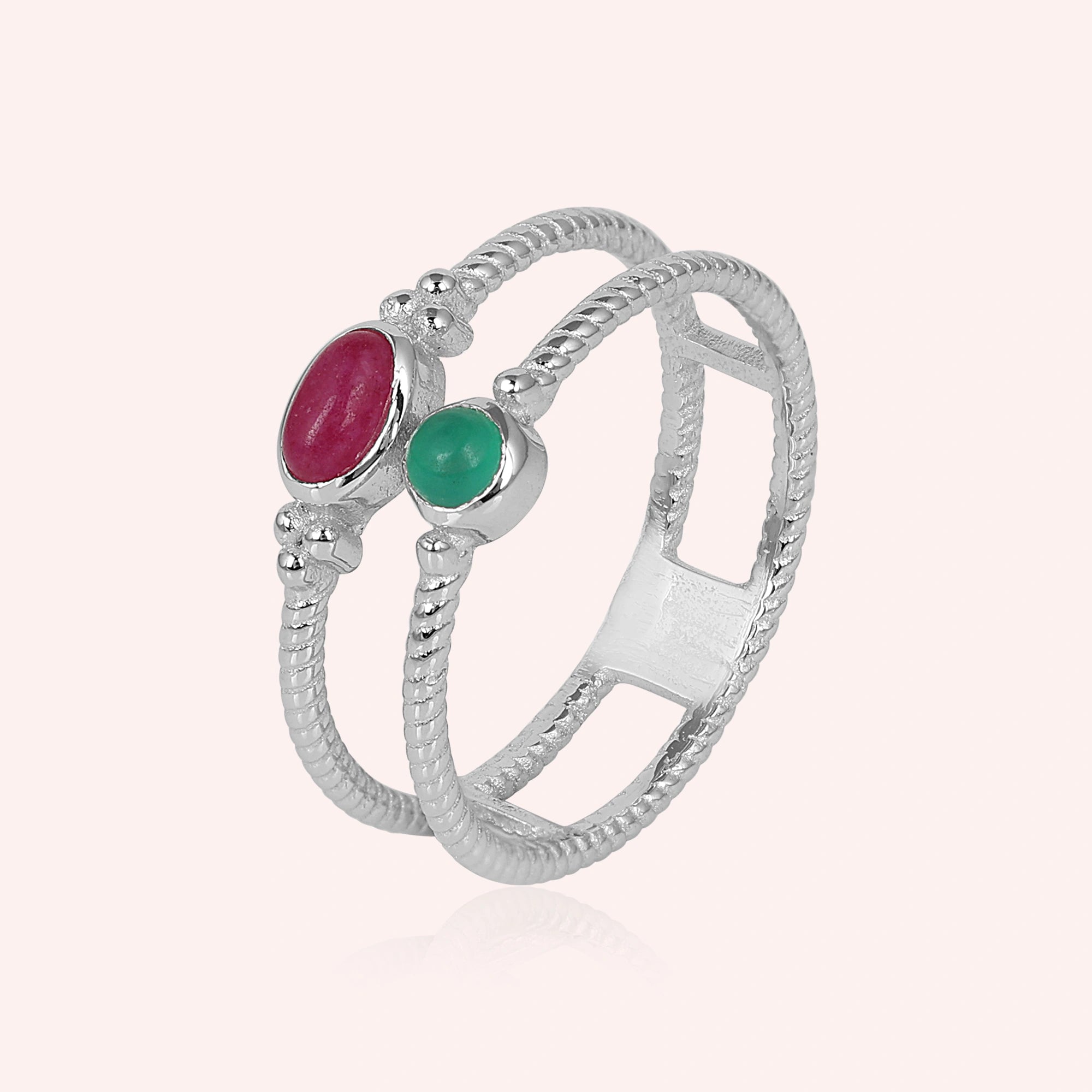 Double_stone_ring_in_sterling_silver_in_slightly_angle_with_ruby_and_green_onyx_stones_on_solid_pink_background